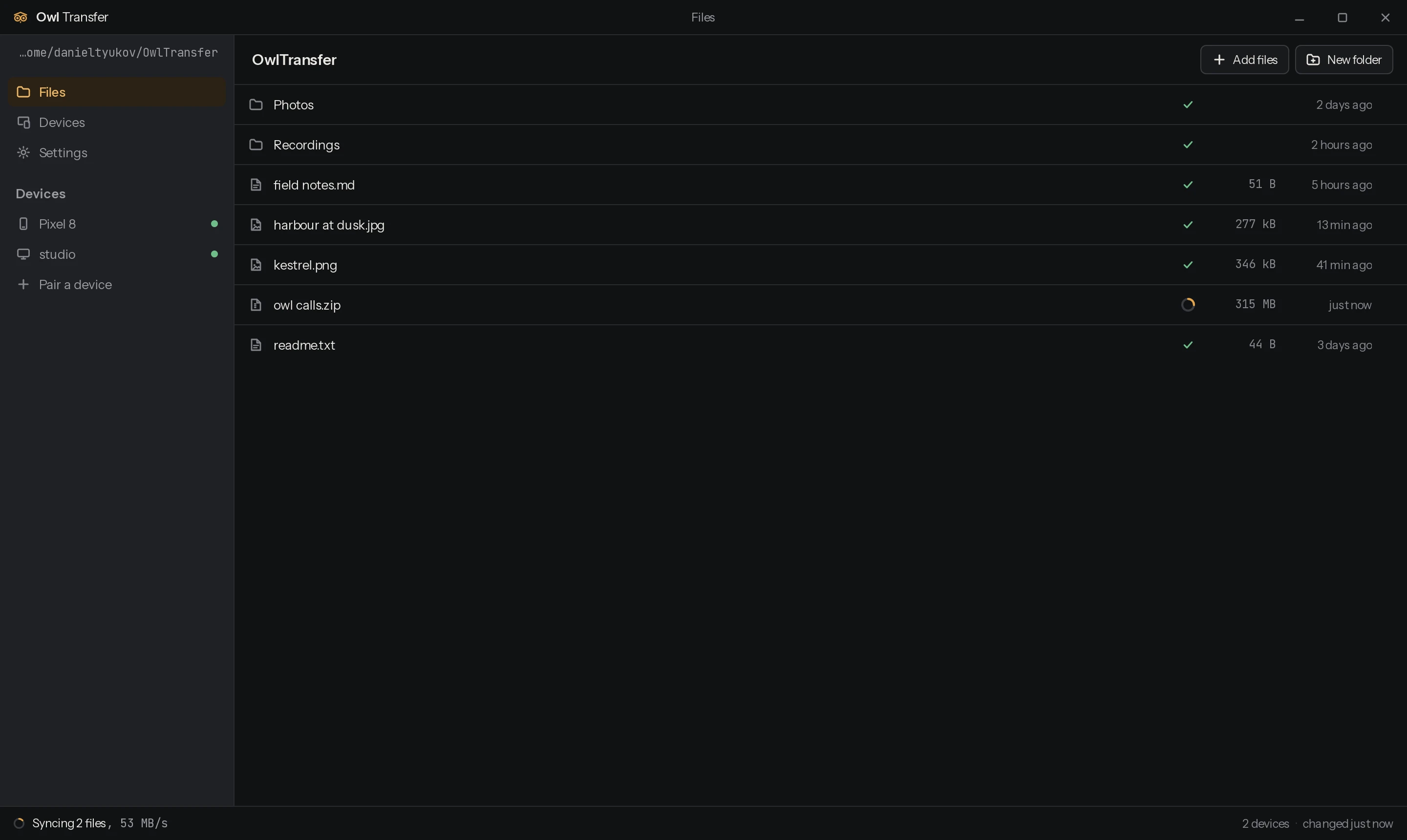 The OwlTransfer desktop app: a sidebar with the sync folder and two paired devices each showing a status dot, a file list in the middle with a sync badge beside every name and one file part way through, and a status strip along the bottom.
