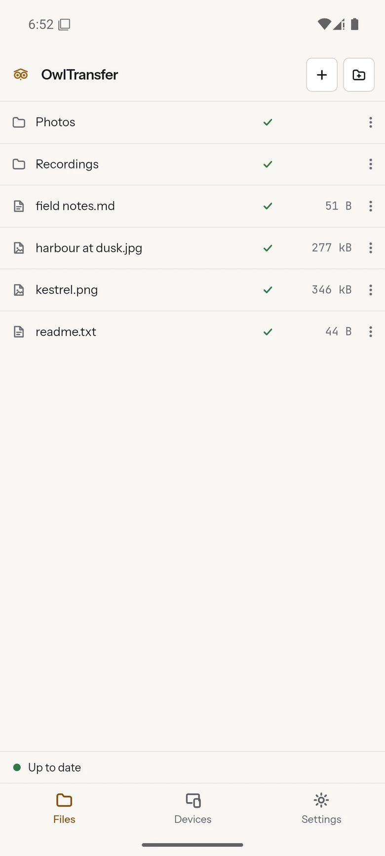 The same folder on a phone: a header with the owl mark and the OwlTransfer wordmark beside buttons for adding files and making a folder, a file list with a green sync badge and a size beside every name, a status strip along the bottom reading Up to date, and tabs for Files, Devices and Settings under it.